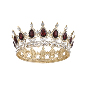 Ornate gold baroque bridal crown featuring red teardrop gemstones and clear crystals