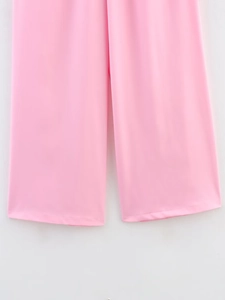 Detailed close-up of pink wide-leg trousers showing smooth drape and soft fabric texture