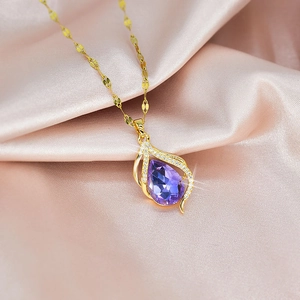 Elegant gold-tone drop necklace with a purple crystal pendant on pink silk background