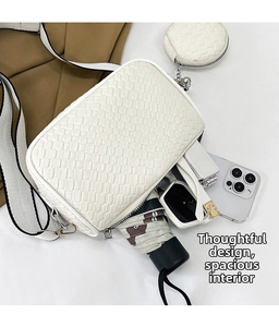 Interior storage space of woven crossbody bag with wide strap and matching round coin purse