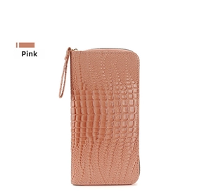 Detalle de cartera larga rosa con textura de cocodrilo y una correa de muñeca a juego