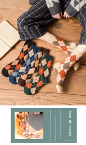 Detail view of thick argyle knit crew socks in retro autumn colors on a wooden floor