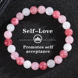 Detailed view of pink crystal beaded bracelet on black leather base with self-love card