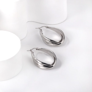 Detail shot of silver triple-layered interwoven hoop earrings with high polish finish