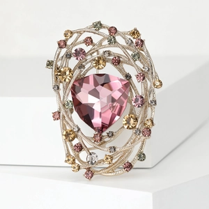 Detailed macro view of the bird nest brooch featuring a large pink crystal and rhinestones
