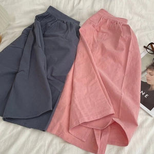 Detail view of cotton waist aprons showing natural texture and pleated waist design