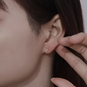 Close-up of 999 sterling silver constellation stud earring with sparkling cubic zirconia