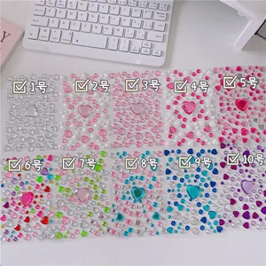 Flat lay of heart-shaped acrylic gemstone stickers in ten diverse color palettes for DIY