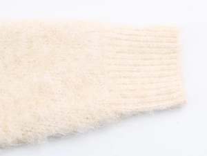 Detailed macro view of the ribbed knit cuff on a beige mohair sweater for women