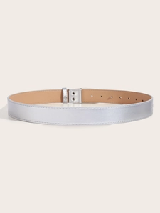 Detail view of a vintage silver rhinestone buckle on a black leather belt with stud accents