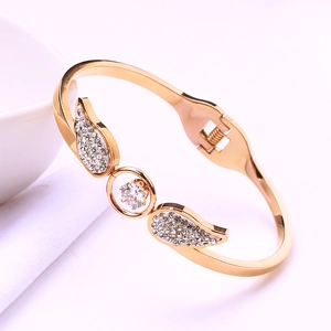 Macro shot of rose gold angel wing bracelet featuring pave zircons and center stone