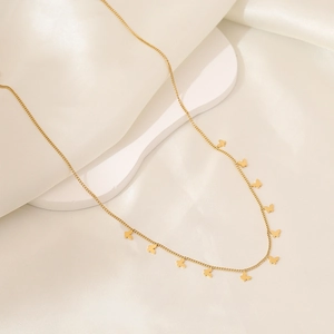 Golden butterfly necklace on cream silk fabric with minimalist chain link detailing