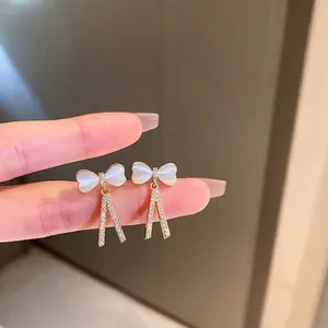 Boucles d'oreilles nœud dorées avec pendentifs en zircon et pierre œil de chat