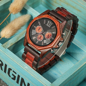 Macro detail of a sandalwood quartz watch displayed in a blue wooden box with dry flowers