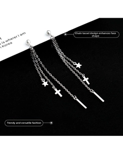 Detail of silver long tassel earrings with star and cross charms on bicolour background