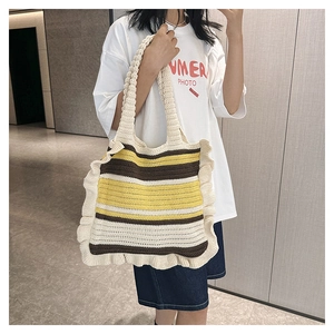 Close-up of hand-knitted tote bag featuring ruffles and striped crochet textures