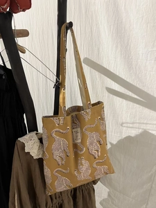 Détail d'un sac cabas en toile à imprimé guépard avec étiquette de marque Animal Passion
