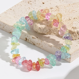 Detail of colorful irregular natural stone beads on an elastic bracelet on stone surface