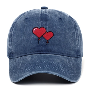 Close-up of dual red heart balloon embroidery on blue washed denim baseball cap