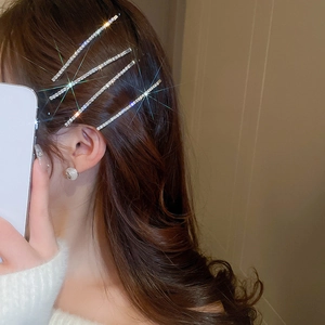 Detail of four-piece silver rhinestone hair clips set on wavy brown hair