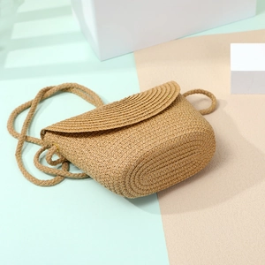 Close-up of hand-woven straw crossbody shell bag with flap and textured rope strap