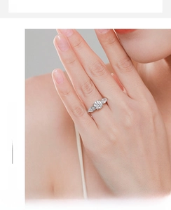 Macro detail of silver three-stone ring with round and pear-cut cubic zirconia stones