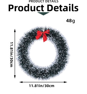 Detail of a 30cm green tinsel Christmas wreath with red bow and white snow-tipped needles