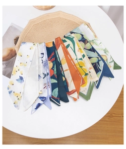 Flat lay of diverse floral print skinny scarves and neck ribbons on a cork display