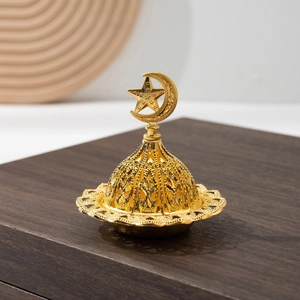 Détail d'un brûle-encens arabe doré avec motifs ajourés et symbole étoile de lune