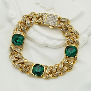 Détail d'un bracelet cubain doré avec strass et pierres précieuses vertes carrées