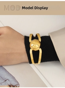 Detail shot of a minimalist gold hollow cuff bracelet featuring a large metal sphere