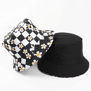 Détail d'un chapeau bob réversible avec motif à damier noir et blanc et imprimé marguerites