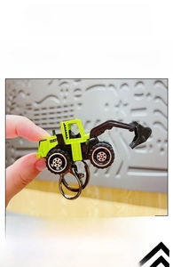 Detail view of mini alloy excavator keychain in neon green and black finish