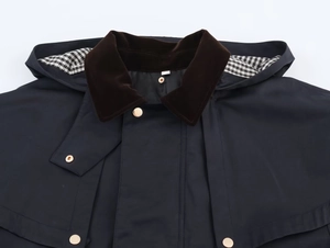 Detail of hooded jacket featuring brown velvet stand collar and black and white plaid lining