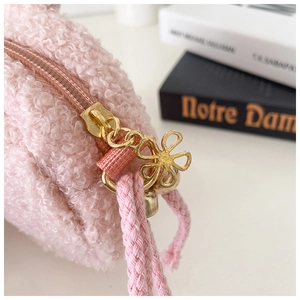 Detailed macro view of pink fuzzy plush coin purse with floral gold metal zipper pull