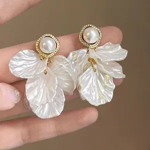 Vue macro de boucles d'oreilles vintage avec perle et pétales de fleurs irisées