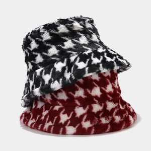 Close-up of black and red houndstooth plush bucket hats with soft faux fur texture
