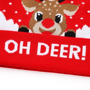 Gros plan sur un bonnet de Noël rouge tricoté avec motif renne et texte OH DEER