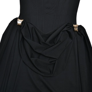 Détails de la robe noire cintrée avec boucle en métal doré et plis élégants à la taille