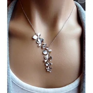 Élégant ensemble de collier à pétales d'orchidées argentées porté par un mannequin