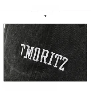 Close-up of St. Moritz white embroidery on black washed cotton baseball cap texture