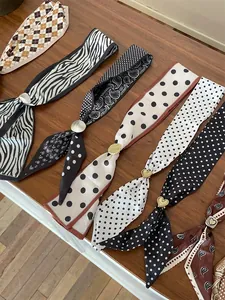 Close-up of silk scarf necklaces with paisley patterns and gold heart buckles
