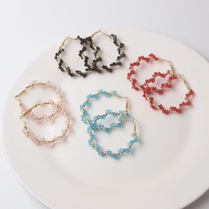 Detailed macro view of colorful beaded hoop earrings in black, red, pink and blue
