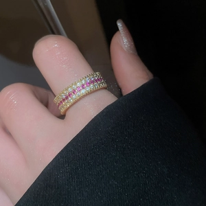 Dettaglio macro di un anello placcato oro 18 carati a tre file con zirconi rosa e bianchi