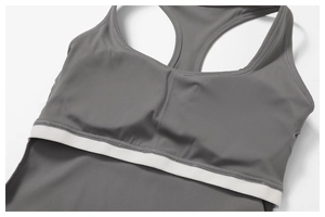 Close-up of gray sports bra with racerback design and white elastic hem detail