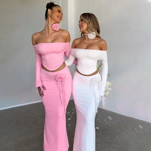 Detail of slim fit ribbed knit sets featuring strapless long sleeve tops and maxi skirts
