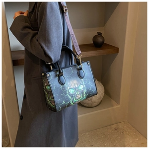 Detail of printed skull tote bag showing the green lightning design and fashion strap