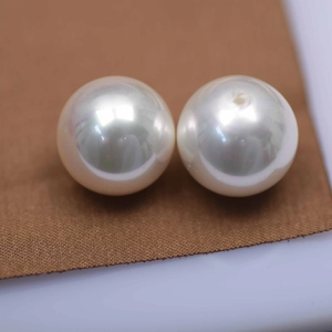 Macro detail of high-luster white round glass pearls with fine pre-drilled holes
