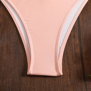Detailed close-up of pink ribbed fabric bikini bottom with premium double stitching