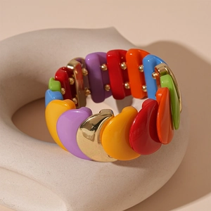 Detail view of colorful acrylic geometric segments and gold metal links on a bracelet
